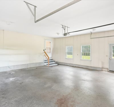 Spacious garage with ample natural light, featuring easy access to the backyard through a side door.