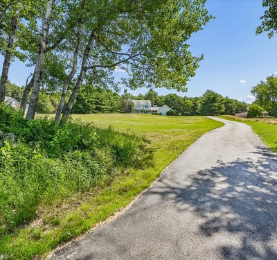 Nestled on a spacious lot, this property features a winding driveway and picturesque natural surroundings.