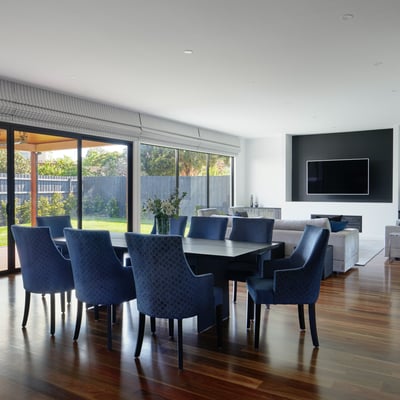 Spacious open-plan living and dining area features stunning hardwood floors and a bright outdoor view.