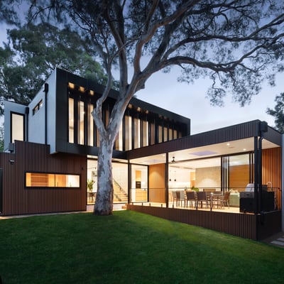 Stunning modern home featuring expansive windows, sleek design, and lush greenery for a serene living experience.