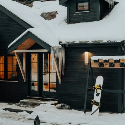 Cozy mountain retreat with ski-in access, featuring a snow-covered exterior and inviting entryway.