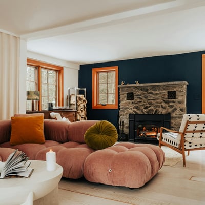 Cozy living room featuring a unique stone fireplace, modern furniture, and large windows for natural light.