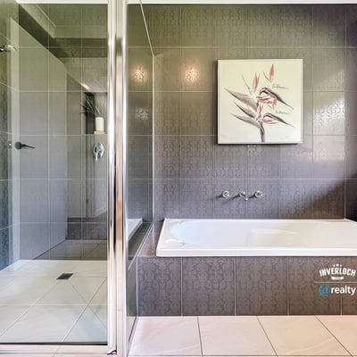 Spacious bathroom featuring a double vanity, modern shower, and relaxing bathtub for ultimate comfort.