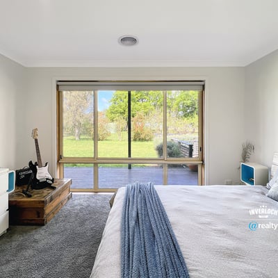 Bright bedroom featuring a large window with garden views, complemented by modern furnishings and cozy atmosphere.