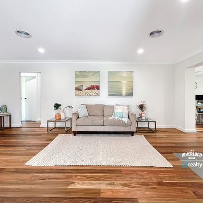Bright and spacious living area featuring warm wooden floors, modern artwork, and an inviting atmosphere.