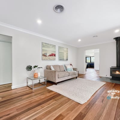 Spacious living area featuring hardwood floors and a cozy wood-burning stove, perfect for gatherings and relaxation.