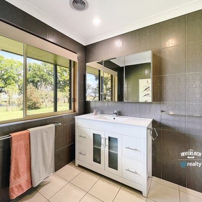 Bright and airy bathroom featuring modern fixtures, ample natural light, and scenic garden views.