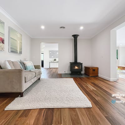 Spacious living area featuring natural light, modern decor, and a cozy fireplace, perfect for gatherings.