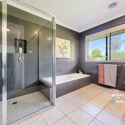 Modern bathroom featuring sleek tiles, a spacious shower, and large windows for natural light.