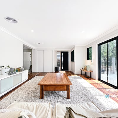 Bright open living space featuring large windows, natural light, and a warm wood coffee table.