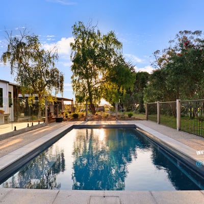 Discover this inviting outdoor space featuring a refreshing pool, surrounded by lush greenery and modern amenities.