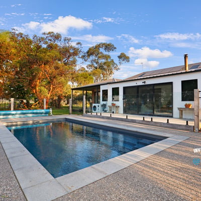 Contemporary home featuring an inviting pool area, surrounded by lush landscaping and ample outdoor space for relaxation.