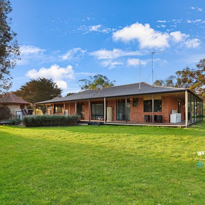 Spacious home set on expansive grounds, featuring large windows and a seamless indoor-outdoor living experience.