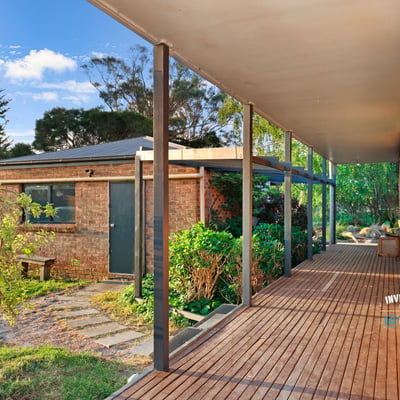 Spacious covered porch leads to a well-maintained garden, offering a welcoming entry to this unique property.