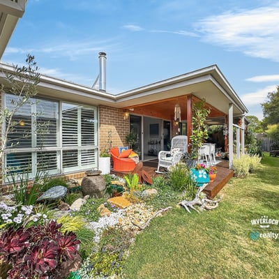 This inviting home features a spacious patio surrounded by vibrant landscaping, perfect for outdoor gatherings.