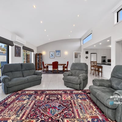 Spacious living area featuring large windows, comfortable seating, and an inviting dining space.