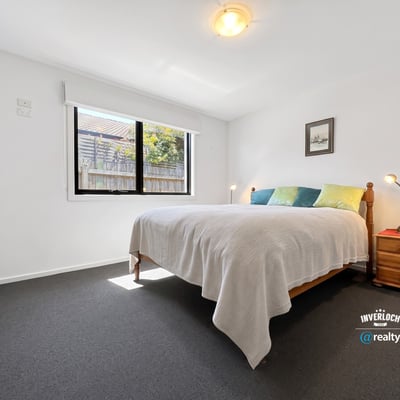 Bright and inviting bedroom with natural light, featuring a comfortable bed and ample closet space.