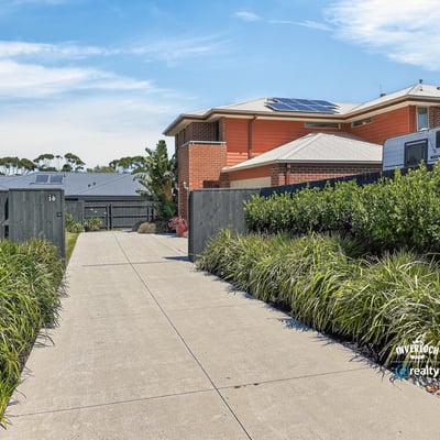 This property features a spacious driveway surrounded by well-maintained landscaping, leading to a modern home.
