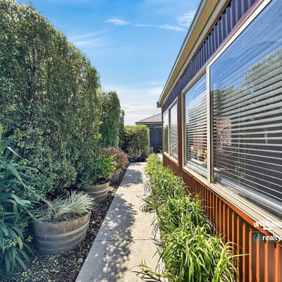 Discover a vibrant pathway lined with lush greenery, leading to inviting outdoor spaces and a welcoming atmosphere.