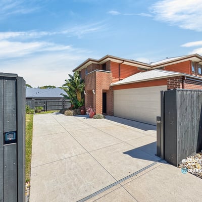 Spacious home with modern features, featuring a large driveway and well-maintained landscaping, perfect for family living.