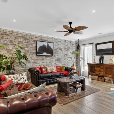 Discover a unique living space featuring exposed brick, vibrant textiles, and natural light, perfect for relaxation.