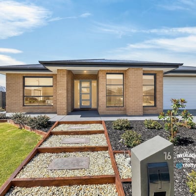 Modern home featuring a welcoming entry, landscaped yard, and large windows for abundant natural light.