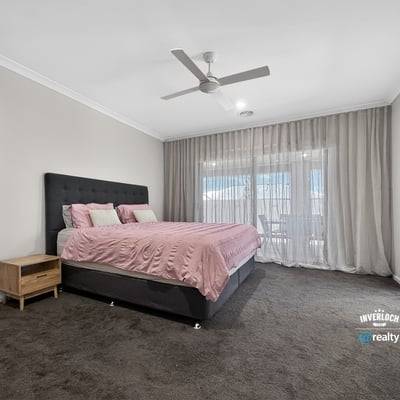 Spacious bedroom featuring a large bed, natural light from expansive windows, and contemporary design elements.