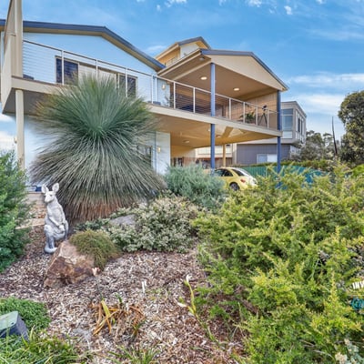 Modern home featuring a spacious design, lush landscaping, and panoramic views in a desirable neighborhood.