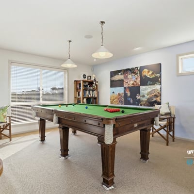Bright recreation room featuring a pool table, ample natural light, and a cozy atmosphere for entertaining.