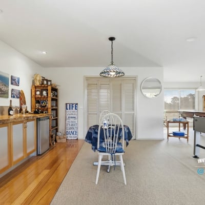 Spacious open-concept living area with natural light, functional bar, and leisure space for entertaining.
