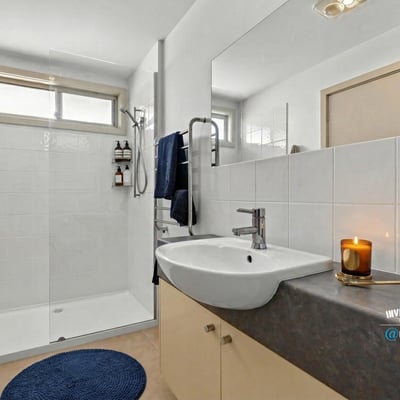 Modern bathroom featuring a spacious shower, sleek fixtures, and ample natural light, perfect for relaxation.