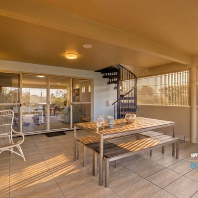 Spacious outdoor terrace featuring a spiral staircase, perfect for relaxation and entertaining with scenic views.