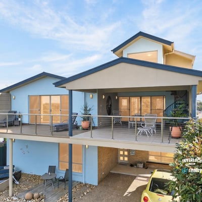 This contemporary home features spacious outdoor living areas and large windows that invite abundant natural light.