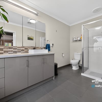 Spacious bathroom featuring modern finishes, a walk-in shower, and ample storage for everyday essentials.