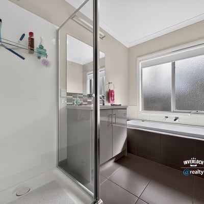 Bright and functional bathroom featuring a glass-enclosed shower and relaxing soaking tub for ultimate convenience.