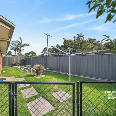 Spacious outdoor area with a fenced yard, perfect for relaxing or gardening on sunny days.