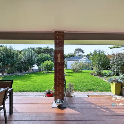 Spacious outdoor patio overlooking a vast, well-maintained garden ideal for entertaining and relaxation.