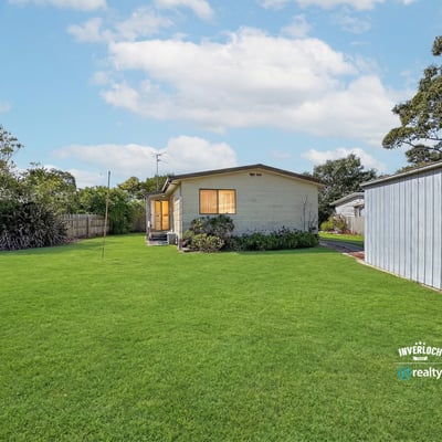 Spacious backyard retreat featuring a well-maintained home, perfect for outdoor activities and family gatherings.