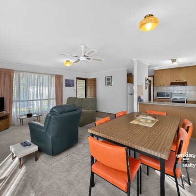 Spacious living area with natural light, featuring a dining space and a functional kitchen layout.