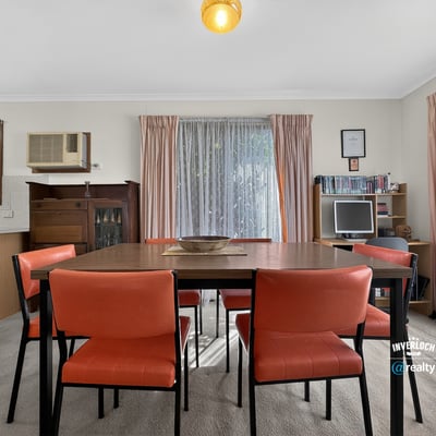 Bright dining area featuring a spacious table and large windows that invite natural light.