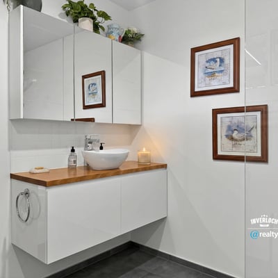 Modern bathroom featuring sleek cabinetry, artistic decor, and contemporary fixtures for a fresh ambiance.
