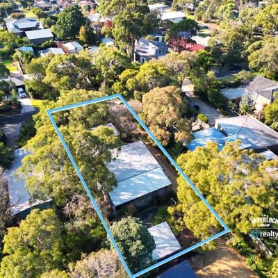 Spacious property surrounded by lush greenery, offering ample outdoor space and potential for development.