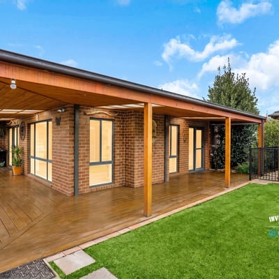 Modern outdoor living area featuring wooden decking, perfect for entertaining in a scenic, landscaped environment.