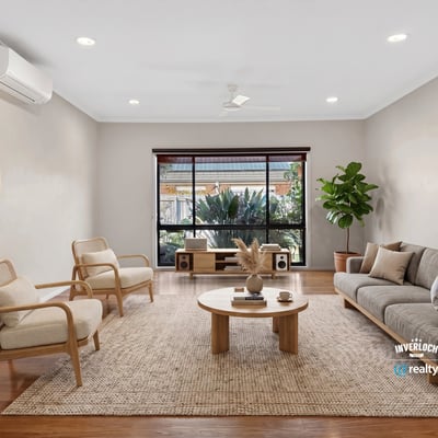 Bright living area features large windows, natural light, and modern furnishings, ideal for relaxed gatherings.