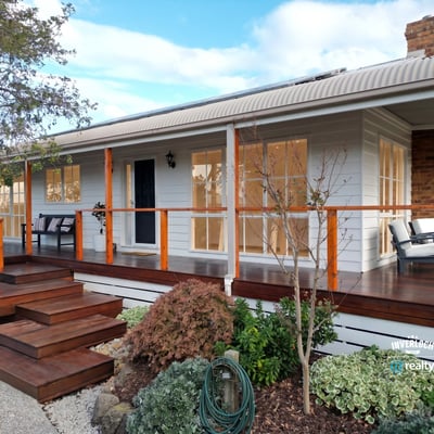 Discover a beautifully designed home featuring a welcoming porch and well-maintained landscaping, perfect for outdoor enjoyment.