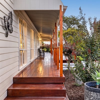 Experience the inviting atmosphere of this well-appointed home with a spacious front porch and lush surroundings.