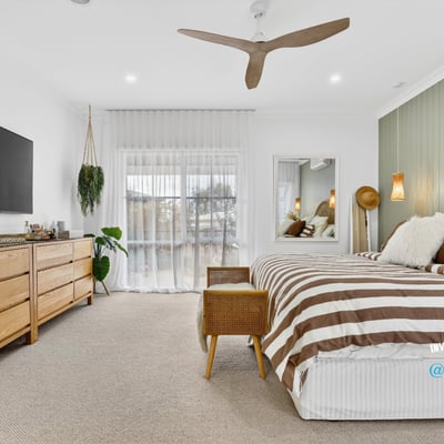 Bright and spacious bedroom featuring natural wood accents, large windows, and modern amenities for comfort.