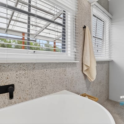 Bright and modern bathroom featuring a spacious tub and large windows for ample natural light.