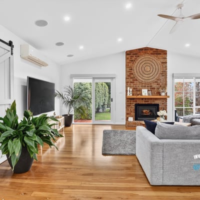 Bright, open living space featuring a distinctive brick fireplace and inviting natural light throughout.
