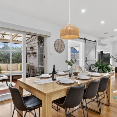 Spacious dining area with natural light, leading to a cozy outdoor retreat for entertaining.